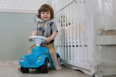 Kleiner Junge sitzen auf einem Spielzeugauto Stockfotografie Kleiner Junge sitzen auf einem Spielzeugauto Stockfotografie