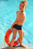 Kleiner Junge zieht Boje vom Schwimmbad aus lizenzfreies stockfoto Kleiner Junge zieht Boje vom Schwimmbad aus lizenzfreies stockfoto