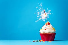 Kleiner Kuchen mit Wunderkerze auf Blau lizenzfreies stockbild Kleiner Kuchen mit Wunderkerze auf Blau lizenzfreies stockbild