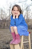 Kleines Mädchen, das auf einem Stepstool lächelt und sitzt lizenzfreie stockfotos Kleines Mädchen, das auf einem Stepstool lächelt und sitzt lizenzfreie stockfotos