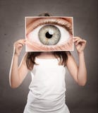 Kleines Mädchen, das ein Bild eines Augenaufpassens hält lizenzfreies stockfoto Kleines Mädchen, das ein Bild eines Augenaufpassens hält lizenzfreies stockfoto