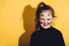 Kleines Mädchen mit Katzenmake-up auf ihrem Gesicht lizenzfreie stockfotografie Kleines Mädchen mit Katzenmake-up auf ihrem Gesicht lizenzfreie stockfotografie