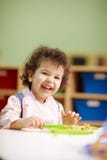 Kleines Mädchen, welches das Mittagessen im Kindergarten isst stockfoto Kleines Mädchen, welches das Mittagessen im Kindergarten isst stockfoto