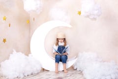 Kleines nettes Mädchen, das auf dem Mond mit Wolken und Sternen mit einem Buch in ihren Händen und in Ablesen sitzt Das M?dchen l stockfotografie Kleines nettes Mädchen, das auf dem Mond mit Wolken und Sternen mit einem Buch in ihren Händen und in Ablesen sitzt Das M?dchen l stockfotografie
