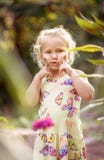 Kleines schönes blondes lächelndes Mädchen wirft Gesichtsnahaufnahme auf lizenzfreies stockbild Kleines schönes blondes lächelndes Mädchen wirft Gesichtsnahaufnahme auf lizenzfreies stockbild