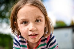 Kleinkind mit schmutzigem Gesicht vom Spielen draußen im Schmutz und stockfotografie Kleinkind mit schmutzigem Gesicht vom Spielen draußen im Schmutz und stockfotografie