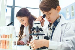 Kleinkinder, die Chemie im Schullabormikroskopexperiment lernen stockfotografie Kleinkinder, die Chemie im Schullabormikroskopexperiment lernen stockfotografie