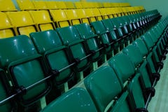 Klingerytów krzesła dla widzów w gym Audytorium z rzędami nastroszeni zieleni i koloru żółtego siedzenia zdjęcie stock Klingerytów krzesła dla widzów w gym Audytorium z rzędami nastroszeni zieleni i koloru żółtego siedzenia zdjęcie stock