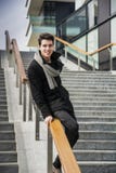 In knappe jonge mens op de wintermanier die zich op een lange trap bevinden stock foto In knappe jonge mens op de wintermanier die zich op een lange trap bevinden stock foto