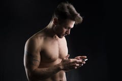 Knappe shirtless spier jonge mens die celtelefoon met behulp van Stock Afbeelding Knappe shirtless spier jonge mens die celtelefoon met behulp van Stock Afbeelding