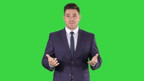 Knappe zakenman die in camera en op het Groen Scherm, Chromasleutel spreken kijken stock videobeelden Knappe zakenman die in camera en op het Groen Scherm, Chromasleutel spreken kijken stock videobeelden