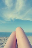 Knees of a young woman sunbathing on the beach, retro/vintage