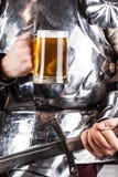 knight a armadura vestindo e caneca guardar de cerveja e de swor de duas mãos imagem de stock knight a armadura vestindo e caneca guardar de cerveja e de swor de duas mãos imagem de stock