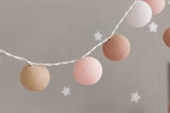 Knitted lights garland for party - christmas or valentines day, wedding decorations. Close-up shot isolated on gray wall