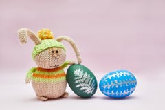 Knitted rabbit and two Easter eggs for a postcard. stock photo Knitted rabbit and two Easter eggs for a postcard. stock photo