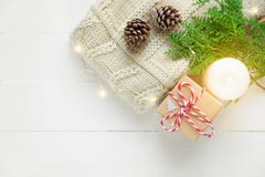 Knitted sweater sweater gift box pine cones green juniper twig golden lights garland candle on wood. Christmas royalty free stock image Knitted sweater sweater gift box pine cones green juniper twig golden lights garland candle on wood. Christmas royalty free stock image