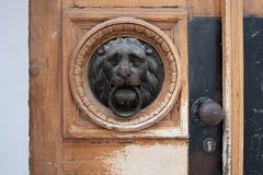 Knocker двери льва главный на деревянной двери стоковое изображение Knocker двери льва главный на деревянной двери стоковое изображение