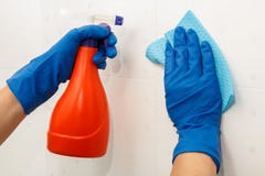 Kobiet ręki w błękitnej gumowej rękawiczka chwytów butelce detergent i obrazy stock Kobiet ręki w błękitnej gumowej rękawiczka chwytów butelce detergent i obrazy stock