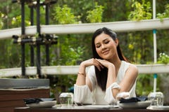 Kobieta bielu skrótu suknia siedzi w Zielarskiej restauracji zdjęcia stock Kobieta bielu skrótu suknia siedzi w Zielarskiej restauracji zdjęcia stock