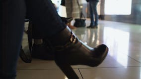 Kobieta czeka lot w lotnisku w heeled butach, podróż służbowa, zbliżenie zbiory wideo Kobieta czeka lot w lotnisku w heeled butach, podróż służbowa, zbliżenie zbiory wideo