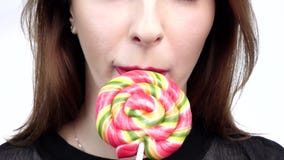 Kobieta liże cukierek z pięknym makijażem odizolowywającym na białym tle zbliżenie zbiory Kobieta liże cukierek z pięknym makijażem odizolowywającym na białym tle zbliżenie zbiory