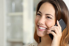 Kobieta opowiada na telefonie komórkowym w domu Kobieta opowiada na telefonie komórkowym w domu