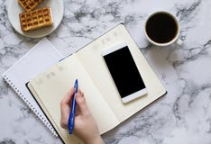 Kobieta planuje dzień, kawa, gofry, marmurowy tło, smartphone zdjęcia stock Kobieta planuje dzień, kawa, gofry, marmurowy tło, smartphone zdjęcia stock