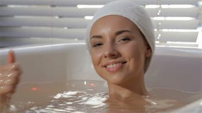 Kobieta pokazuje jej kciuk up przy leczniczym skąpaniem zbiory wideo Kobieta pokazuje jej kciuk up przy leczniczym skąpaniem zbiory wideo
