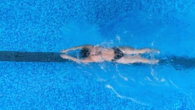 Kobieta pływa w motyla stylu i utrzymuje jej głowę podwodna zbiory Kobieta pływa w motyla stylu i utrzymuje jej głowę podwodna zbiory