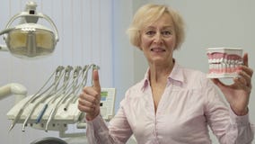 Kobieta trzyma układ ludzcy zęby zbiory wideo Kobieta trzyma układ ludzcy zęby zbiory wideo