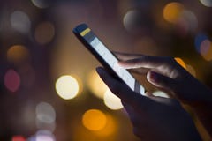 Kobieta używa jej telefon komórkowego, miasto linii horyzontu nocy światła backgro zdjęcia stock Kobieta używa jej telefon komórkowego, miasto linii horyzontu nocy światła backgro zdjęcia stock