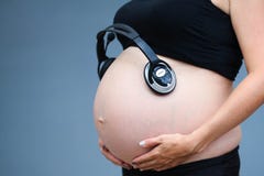 Kobieta w ciąży jest brzuchem Nienarodzone dziecko słucha muzyka z headp obraz stock Kobieta w ciąży jest brzuchem Nienarodzone dziecko słucha muzyka z headp obraz stock