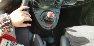 Kobieta w czerwonym mini sukni obsiadaniu na kierowcy siedzeniu jej ręka na kierownicie fotografia stock Kobieta w czerwonym mini sukni obsiadaniu na kierowcy siedzeniu jej ręka na kierownicie fotografia stock