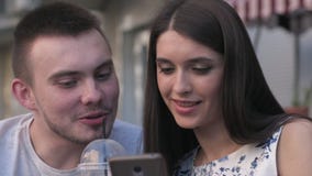 Kobieta w mężczyzna dopatrywania fotografiach na smartphone lato kawiarnia zbiory Kobieta w mężczyzna dopatrywania fotografiach na smartphone lato kawiarnia zbiory