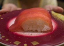 Kobieta w żółtej koszulce stał przynosić talerza świeży japończyka Akami Nigiri suszi Makuro zdjęcie stock Kobieta w żółtej koszulce stał przynosić talerza świeży japończyka Akami Nigiri suszi Makuro zdjęcie stock