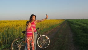 Kobieta z dzieckiem robi selfie w naturze Szczęśliwa matka z jej córką fotografuje w wsi Cykliści robią jaźni zbiory Kobieta z dzieckiem robi selfie w naturze Szczęśliwa matka z jej córką fotografuje w wsi Cykliści robią jaźni zbiory