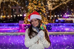 Kobieta z Santa kapeluszem przed Bożenarodzeniowym lodowym lodowiskiem zdjęcia stock Kobieta z Santa kapeluszem przed Bożenarodzeniowym lodowym lodowiskiem zdjęcia stock