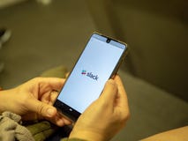 Kobiety otwarcia zastoju komunikacji mobilnej app z logo na Android ekranie podczas gdy dojeżdżać do pracy na metrze fotografia stock Kobiety otwarcia zastoju komunikacji mobilnej app z logo na Android ekranie podczas gdy dojeżdżać do pracy na metrze fotografia stock