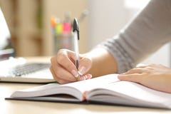 Kobiety ręki writing w agendzie w domu obraz stock Kobiety ręki writing w agendzie w domu obraz stock