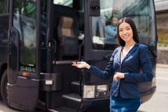 Kobiety stewardesa pozuje przeciw tłu czarny autobus na którym pracuje zdjęcie stock Kobiety stewardesa pozuje przeciw tłu czarny autobus na którym pracuje zdjęcie stock