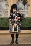 Kobza gracz Ubierający w Kilt Bawić się na przodzie Hilton hotel w Glasgow, Szkocja fotografia royalty free Kobza gracz Ubierający w Kilt Bawić się na przodzie Hilton hotel w Glasgow, Szkocja fotografia royalty free