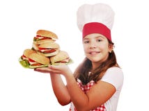 Koch des kleinen Mädchens mit Hamburgern auf Platte Lizenzfreies Stockbild Koch des kleinen Mädchens mit Hamburgern auf Platte Lizenzfreies Stockbild