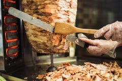 Kochen von shawarma und von ciabatta in einem Café Ein Mann im Wegwerfhandschuh-Schnittfleisch auf einer Aufsteckspindel stockbilder Kochen von shawarma und von ciabatta in einem Café Ein Mann im Wegwerfhandschuh-Schnittfleisch auf einer Aufsteckspindel stockbilder