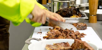 Kock som skivar lagat mat kött arkivfoto Kock som skivar lagat mat kött arkivfoto