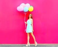 Koel meisje die met een lucht kleurrijke ballons over een roze lopen stock afbeeldingen Koel meisje die met een lucht kleurrijke ballons over een roze lopen stock afbeeldingen