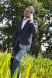 Koele jaren '40zakenman die met celtelefoon spreken in groen park royalty-vrije stock fotografie Koele jaren '40zakenman die met celtelefoon spreken in groen park royalty-vrije stock fotografie
