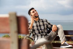 Koele jonge Arabische mens die op mobiele telefoon in openlucht spreken Royalty-vrije Stock Fotografie Koele jonge Arabische mens die op mobiele telefoon in openlucht spreken Royalty-vrije Stock Fotografie