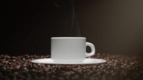 Koffiekop en koffiebonen Witte Kop van het stomen van koffie met geroosterde bonen rond het stock video Koffiekop en koffiebonen Witte Kop van het stomen van koffie met geroosterde bonen rond het stock video