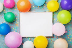 Kolorowi balony, srebro rama i confetti na błękitnego tła odgórnym widoku, Urodziny lub przyjęcia mockup dla planować mieszkanie Zdjęcie Stock Kolorowi balony, srebro rama i confetti na błękitnego tła odgórnym widoku, Urodziny lub przyjęcia mockup dla planować mieszkanie Zdjęcie Stock