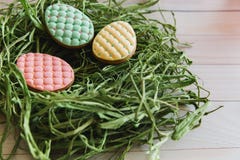 Kolorowi Easter jajek ciastka w gniazdeczku na lekkim drewnianym tle zdjęcie stock Kolorowi Easter jajek ciastka w gniazdeczku na lekkim drewnianym tle zdjęcie stock